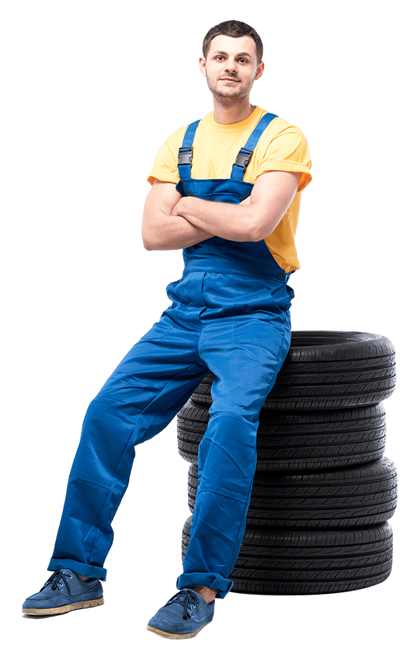 mechanic sitting on a stack of 4 tires